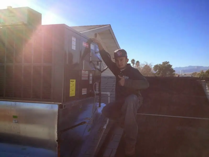 HVAC technician performing Boiler Repair on a rooftop unit in Prairie Village
